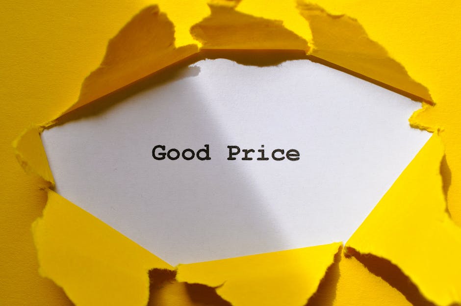 A white card with the words 'Good Price' printed in black, visible through a torn yellow paper background. The torn edges of the yellow paper create a rough frame around the card, contrasting the smoo